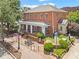 A charming brick building features a covered patio, landscaped front yard, and a street sign at 365 Norcross St, Roswell, GA 30075