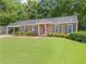Charming brick home features a covered carport, well-kept lawn and manicured shrubs at 365 Norcross St, Roswell, GA 30075