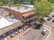 Busy street view of a multi-story brick building with a restaurant and outdoor seating area at 365 Norcross St, Roswell, GA 30075