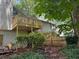 Backyard featuring a tiered wooden deck and patio area, surrounded by lush greenery at 390 Hunt River Way, Suwanee, GA 30024