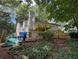 Backyard featuring a tiered wooden deck, lush greenery, and exterior access at 390 Hunt River Way, Suwanee, GA 30024