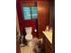 Cozy bathroom featuring dark red walls, a toilet, vanity with sink, and storage space at 390 Hunt River Way, Suwanee, GA 30024