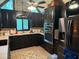 Remodeled kitchen featuring modern appliances, dark cabinets, and tile flooring at 390 Hunt River Way, Suwanee, GA 30024