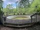 A weathered above ground pool with wooden deck, providing a rustic and unique backyard feature at 390 Hunt River Way, Suwanee, GA 30024