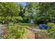 Overgrown backyard with a fence, shed, and some green trash bins at 1143 Westview Sw Dr, Atlanta, GA 30310