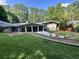 Manicured backyard featuring a covered patio, fire pit with Adirondack chairs, and ample lawn space at 2062 Valiant Ne Dr, Atlanta, GA 30345