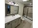 This well-lit bathroom offers a sleek, modern vanity and shower-over-tub with dark framed sliding doors at 2062 Valiant Ne Dr, Atlanta, GA 30345