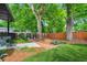 Landscaped backyard featuring a mulched garden area with a wood fence and a view of the home's covered entrance at 23 Walthall Ne St, Atlanta, GA 30317