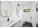 Modern bathroom featuring double sinks, black fixtures, tile floors and a window above the bathtub at 23 Walthall Ne St, Atlanta, GA 30317