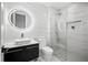 Modern bathroom with walk-in shower, LED mirror, dark vanity, and marble-look tile at 23 Walthall Ne St, Atlanta, GA 30317