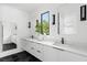 Modern bathroom featuring double vanity, black hexagon tile floors, and sleek fixtures at 23 Walthall Ne St, Atlanta, GA 30317