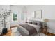 Cozy bedroom with hardwood floors and a large window, featuring a comfortable bed and a decorative tree at 23 Walthall Ne St, Atlanta, GA 30317