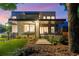 Elegant home exterior at twilight featuring a covered porch, landscape lighting, and a manicured lawn at 23 Walthall Ne St, Atlanta, GA 30317
