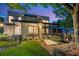 Stunning home exterior at dusk with manicured lawn, covered porch, and landscape lighting for enhanced curb appeal at 23 Walthall Ne St, Atlanta, GA 30317