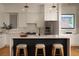 Bright kitchen with white cabinets, black island, stainless appliances, quartz countertop and stylish lighting at 23 Walthall Ne St, Atlanta, GA 30317