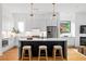 The bright kitchen features white cabinetry, black island, stainless appliances, and modern pendant lights at 23 Walthall Ne St, Atlanta, GA 30317