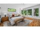 Bright main bedroom with hardwood floors, large windows, and a rustic wood bench at the foot of the bed at 23 Walthall Ne St, Atlanta, GA 30317