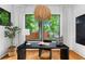 Modern office showcasing a sleek desk, decorative chandelier, and large window with lush greenery views at 23 Walthall Ne St, Atlanta, GA 30317