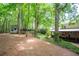 Spacious backyard with a shed and mature trees, leading up to the house with a covered porch at 3788 Westwick Nw Ct, Kennesaw, GA 30152