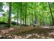 Spacious backyard surrounded by mature trees featuring house and outbuilding on property at 3788 Westwick Nw Ct, Kennesaw, GA 30152
