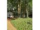 Lush groundcover and mature trees surround the charming playhouse in the backyard, providing a secluded outdoor retreat at 3788 Westwick Nw Ct, Kennesaw, GA 30152