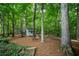 Lush backyard with mature trees, outbuilding, and firepit, offering serene outdoor living at 3788 Westwick Nw Ct, Kennesaw, GA 30152