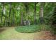 Lush backyard featuring a charming playhouse nestled among the trees and green foliage at 3788 Westwick Nw Ct, Kennesaw, GA 30152