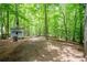 Mature backyard features fire pit area and outbuilding shed with lush greenery all around at 3788 Westwick Nw Ct, Kennesaw, GA 30152