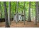 Backyard view featuring an outbuilding surrounded by mature trees in a lush, wooded landscape at 3788 Westwick Nw Ct, Kennesaw, GA 30152