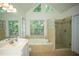 Bright bathroom featuring a jetted tub and separate glass shower at 3788 Westwick Nw Ct, Kennesaw, GA 30152