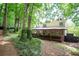 Charming home with a covered porch, lush landscaping, and a walkway through the wooded yard at 3788 Westwick Nw Ct, Kennesaw, GA 30152