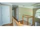 Upstairs hallway with wood floors and railing, white trim, and unique hanging lantern at 3788 Westwick Nw Ct, Kennesaw, GA 30152