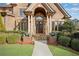 Elegant home entrance with stone columns, arched doorway, and lush landscaping at 511 Baxter Way, Marietta, GA 30064