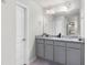 Bathroom with dual sinks, gray cabinets with granite countertops, and modern fixtures with new gray flooring at 9122 Golfview Cir, Covington, GA 30014