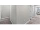 Spacious hallway with neutral-colored walls and carpeted floors, leading to a series of rooms with natural light at 9122 Golfview Cir, Covington, GA 30014