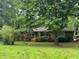 Traditional brick home with a mature tree in the front yard providing shade and curb appeal at 4485 Canary Ct, Lithia Springs, GA 30122