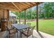 Covered outdoor patio with dining furniture, perfect for al fresco meals overlooking the expansive yard at 6470 Long Island Nw Dr, Atlanta, GA 30328