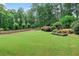 Lush backyard with green lawn, mature trees, and designated dog zone at 6470 Long Island Nw Dr, Atlanta, GA 30328