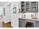 Stylish bar area with granite countertops, wine fridge, and glass-front cabinets at 6470 Long Island Nw Dr, Atlanta, GA 30328