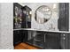 Stylish bar area with marble countertops, black cabinetry, and a circular mirror reflecting the closet at 6470 Long Island Nw Dr, Atlanta, GA 30328
