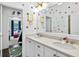 Bright bathroom featuring double vanity with white cabinets, quartz countertops, and colorful polka dot decorations at 6470 Long Island Nw Dr, Atlanta, GA 30328
