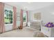 Bright Bedroom with pink floral curtains, a white crib, and an accent chair, creating a calm and inviting space at 6470 Long Island Nw Dr, Atlanta, GA 30328