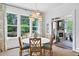 Bright dining room with large windows, stylish chandelier, and views of the outdoor patio at 6470 Long Island Nw Dr, Atlanta, GA 30328