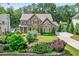 Gorgeous exterior view of a stone and brick home with well-manicured lawn and mature trees at 6470 Long Island Nw Dr, Atlanta, GA 30328