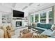 Cozy living room with a stone fireplace and large windows overlooking the backyard at 6470 Long Island Nw Dr, Atlanta, GA 30328