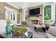 Relaxing outdoor living area with a brick fireplace, TV, comfortable seating, and access to the dining room at 6470 Long Island Nw Dr, Atlanta, GA 30328
