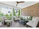 Covered patio features a brick wall, comfortable seating, and a ceiling fan for outdoor relaxation at 6470 Long Island Nw Dr, Atlanta, GA 30328