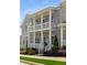 Stately townhomes featuring covered porches, columns, and manicured landscaping at 2125 Parkside Ln, Roswell, GA 30076