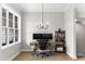 Well-lit home office with dual monitors, modern desk, stylish chandelier and convenient shelving unit at 2125 Parkside Ln, Roswell, GA 30076