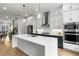 Open concept kitchen boasts stainless steel appliances and a large island with modern lighting at 2125 Parkside Ln, Roswell, GA 30076